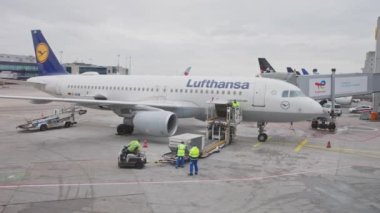 22-01-2023 Frankfurt, Germany: Lufthansa aircraft on the field - loading luggage inside the aircraft. Mid shot