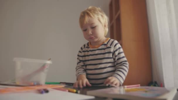 テーブルのそばで色鉛筆で遊んでいるかわいいブロンドの男の子 ミッドショット — ストック動画