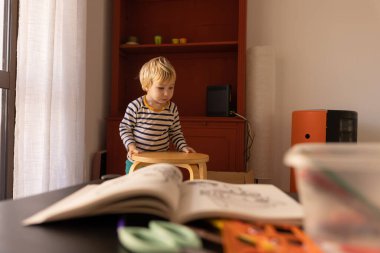 Little Boy Dragging a Wooden Stool. Mid shot