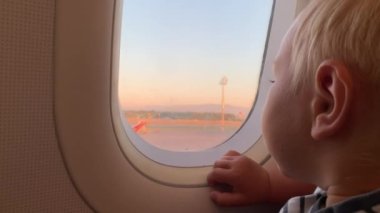 Küçük sarışın bir çocuk lombozdan bakıyor. Portre