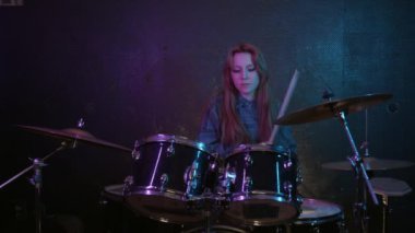 Stüdyoda davul çalan tatlı genç bir kadın. Orta çekim