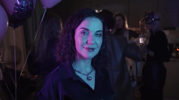 女性のための企業パーティー 女性がネオン青紫色の光の中でカメラの前に立っています 肖像画 — ストック動画