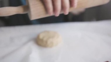 Aile yemeği. Bir kadın masaya çiğ hamur atıyor. Orta çekim