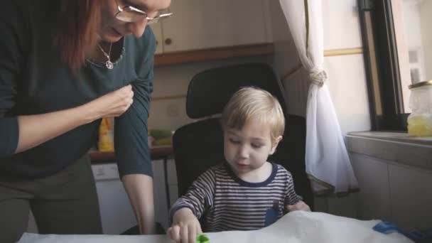 家庭烹调 一个小男孩和他的母亲把饼干模压在生面团上 — 图库视频影像