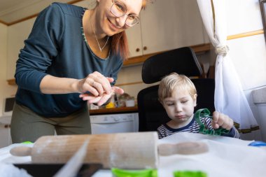 Anne ve oğlu mutfakta kurabiye yapıyor. Orta çekim