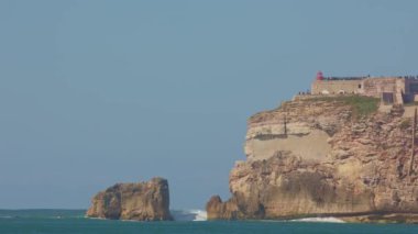 Nazare - sörf için bir yer - insanlar tepedeki gözlem güvertesinde duruyorlar. Orta çekim