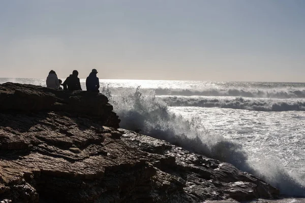 Pessoas Sentam Sobre Pedras Olham Para Mar Meio Tiro — Fotografia de Stock