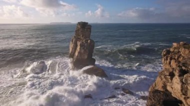 Sea waves crash against the rocks. Mid shot