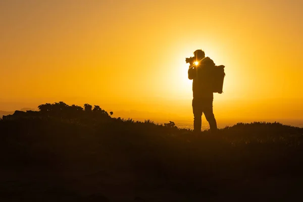 Силует Чоловіка Стоїть Вершині Скелі Фотографує Захід Сонця Середній Постріл — стокове фото