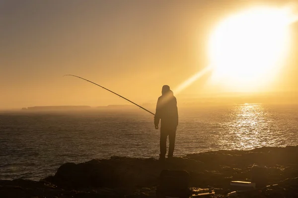 Самотній Чоловік Стоїть Вершині Скелі Рибалить Морі Під Час Заходу — стокове фото