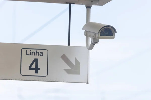 Security CCTV camera and a sign pointing to the way on Linha. Mid shot