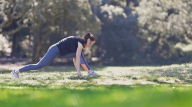 Sporcu kadın vücudunu doğada ısıtıyor. Orta çekim
