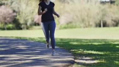 Doğada koşu yaparken gözlük takan bir kadın. Orta çekim