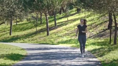 Yetişkin sporcu kadın parkta koşuyor. Orta çekim