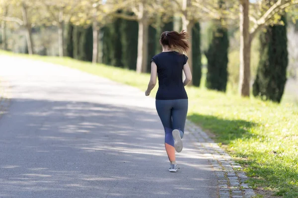公園をジョギングする大人の女性 ミッドショット ロイヤリティフリーのストック写真