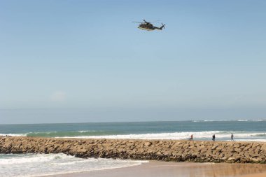 25 Mart 2023 Portekiz, Costa da caparica: bir helikopter denizin üzerinde uçuyor. Orta çekim