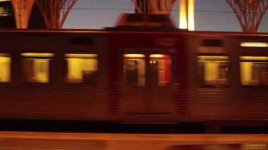 Tren istasyonunun penceresinden ve gün batımını aydınlatan evlerden görüntü. Yolcu POV