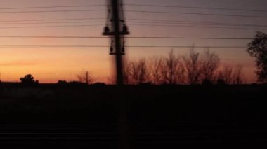 Trenin penceresinden gün batımına ve doğa manzarasına bakın. Yolcu POV