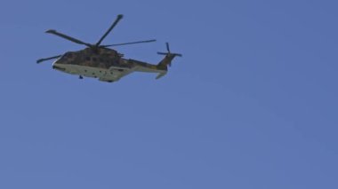 25 Mart 2023 Portekiz, Costa da caparica: Mavi gökyüzünde bir helikopter uçuyor. Orta çekim