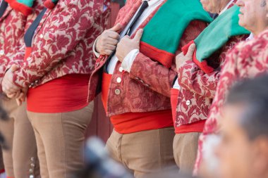 Takım elbiseli forkadolar arenada sırayla duruyorlar. Orta çekim