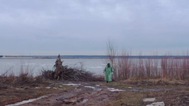 Kıyameti andıran bir kavram. Gaz maskeli bir adam bulutlu bir yerde koruyucu kıyafet giyiyor. Orta çekim