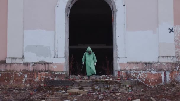 一个戴着防毒面具和防护服的男人走在被丢弃的地方 — 图库视频影像
