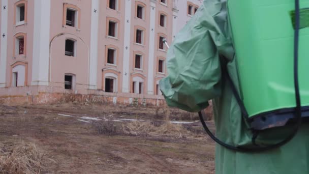 世界末日后的概念 一个戴着防毒面具 身穿防护服 带着化学喷雾器的男人走向一座废弃的建筑 肖像画 — 图库视频影像