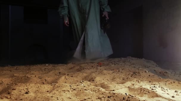 Человек Защитном Костюме Бросает Противогаз Песок Средний Выстрел — стоковое видео