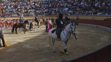 26 Mart 2023 Portekiz, Vila Franca de Xira: Tourada - atlı süvariler arenada yürüyor ve amfitiyatroda seyircileri selamlıyor. Orta çekim