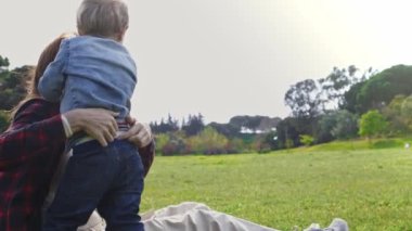 Parkta küçük oğlu olan sevimli bir anne. Orta çekim