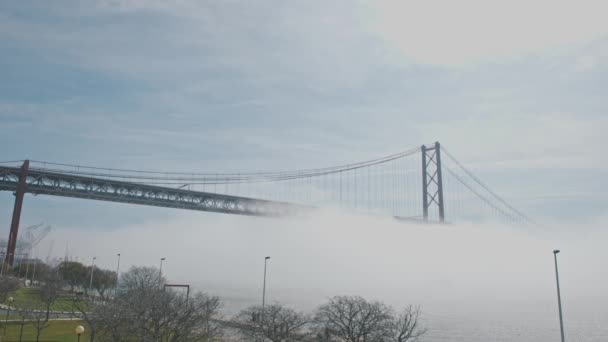 Ponte Suspensão Envolta Nevoeiro Branco Sobre Mar Meio Tiro — Vídeo de Stock
