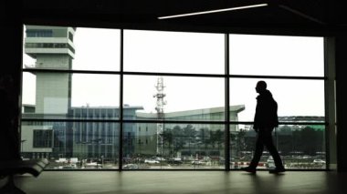 Havaalanında yürüyen meşgul insanların siluetleri. Orta çekim