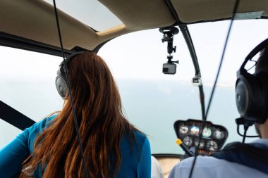 Helikopterde oturan bir kadın yolcu. Orta çekim