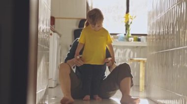 Küçük mutlu çocuk koridorda yüzünde bir gülümsemeyle koşuyor. Orta çekim