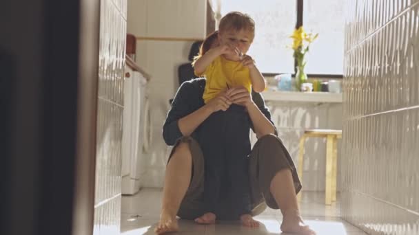 Mama Zakłada Spodnie Swojemu Synowi Podłogę Kuchni Świetle Dziennym Środek — Wideo stockowe