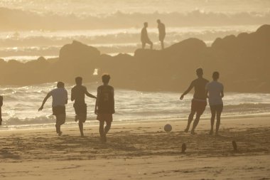 19 Nisan 2023 Lizbon, Portekiz: Costa da Caparica - plajda topla oynayan gençler. Orta çekim