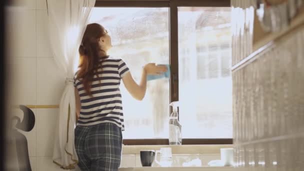 Взрослая Домохозяйка Вытирает Окна Кухне Средний Выстрел — стоковое видео