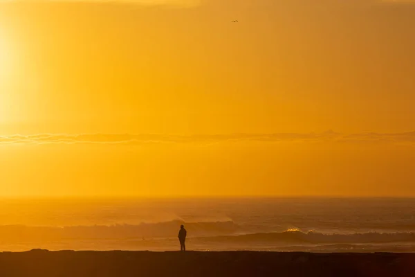 Ein Einsamer Mann Steht Meer Bei Strahlend Orangefarbenem Sonnenuntergang Mittelschuss — Stockfoto