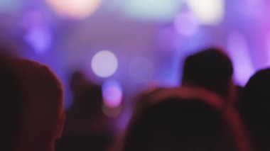 Konserde kalabalığın içindeki bulanık insan siluetleri. Orta çekim