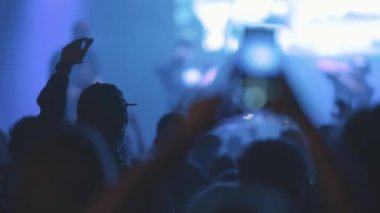 İnsanlar mavi ışıkta canlı bir konserden hoşlanırlar. Orta çekim