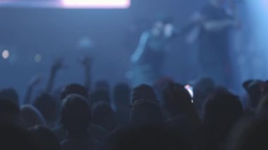 Kalabalıktaki insanların kafaları canlı bir rap konserinin tadını çıkarıyor. Orta çekim