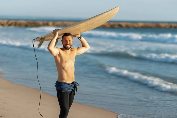 Surfista Sorridente Com Tronco Segurar Uma Prancha Surf Sobre Cabeça — Fotografia de Stock
