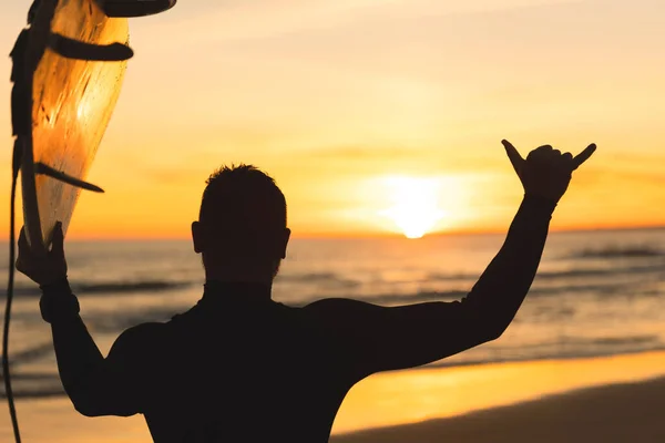 Silhuett Man Som Håller Surfbräda Som Visar Shaka Vid Solnedgången — Stockfoto