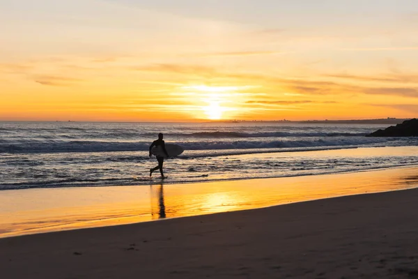 Ein Mann Surft Strand Bei Leuchtend Orangefarbenem Sonnenuntergang Mittelschuss — Stockfoto