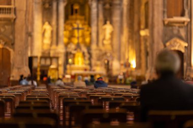 İnsanlar kilisede sandalyeye oturup vaaz dinlerler. Orta çekim