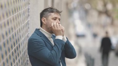 Duvara karşı duran ve caddede mızıka çalan bir adam. Orta çekim