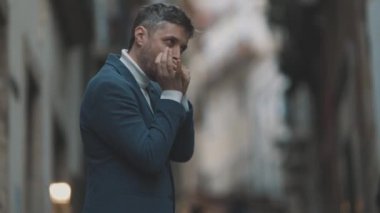 Sokakta bir adam mızıka çalıyor. Orta çekim