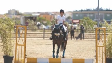 30 Nisan 2023 Sobreda, Portekiz: Festival Hipico da Sobreda - engellerden arenada at üstünde koşan bir kız. Orta çekim