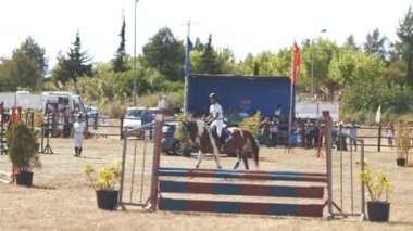 30 Nisan 2023 Sobreda, Portekiz: Festival Hipico da Sobreda - engellerin üzerinde arenada at üstünde yürüyen bir çocuk. Orta çekim