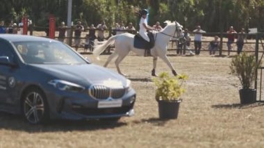 30 Nisan 2023 Sobreda, Portekiz: Festival Hipico da Sobreda - engellerin arasından arenada at sırtında koşan bir çocuk. Orta çekim